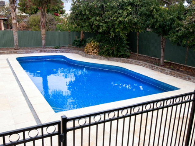 sandstone paved pool with safety barrier fence