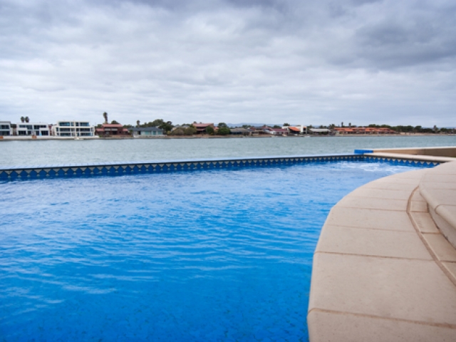 low angle pool with tiled exterior overlooking west lakes