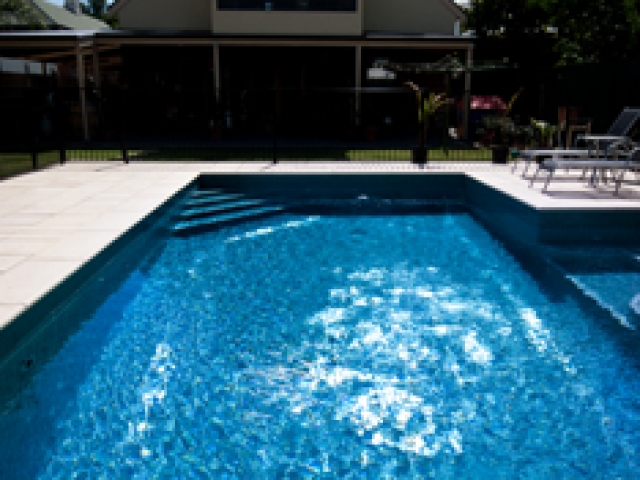 outdoor in ground pool with sunny sky