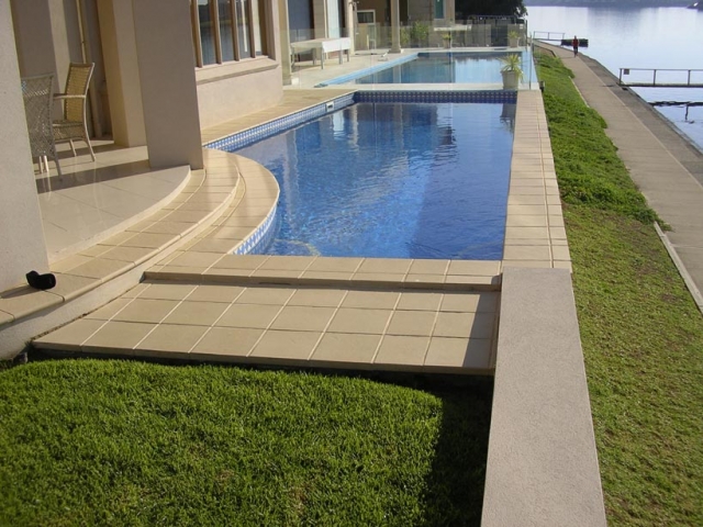 outdoor concrete pool with waterfront view