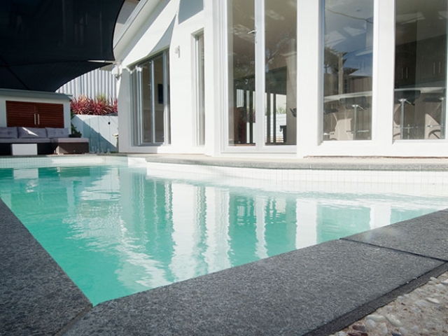 modern customised pool with stone border bespoke upright water feature